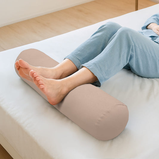 ベッドで足枕を使っている女性の足