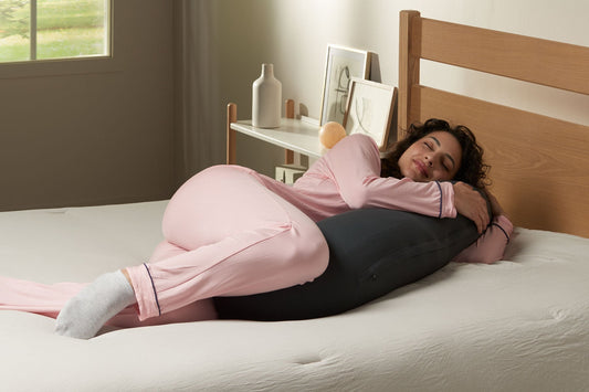 抱き枕を抱いて眠っている女性