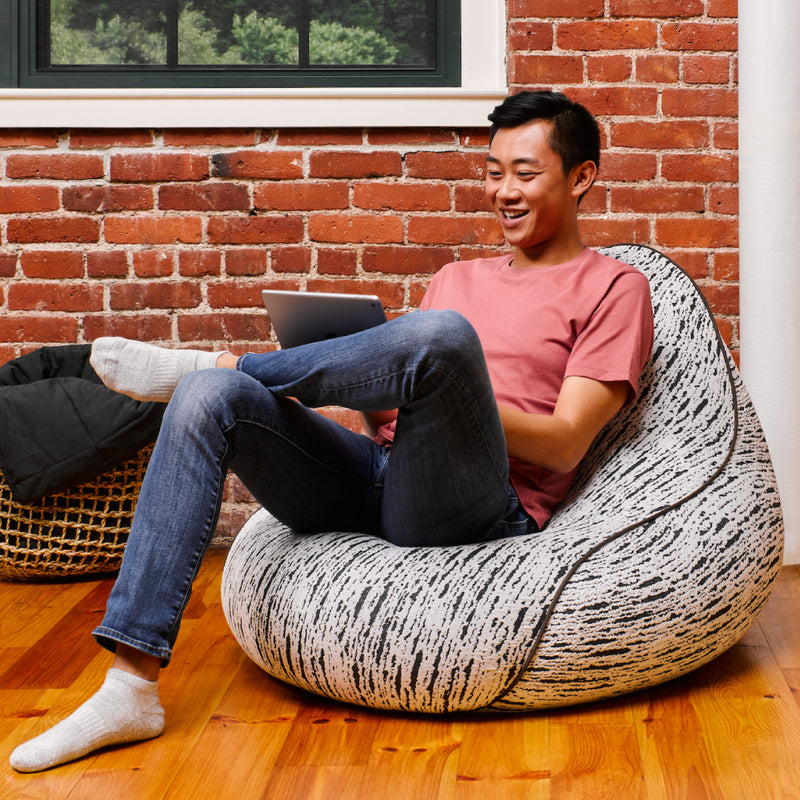 Yogibo Luxe Lounger（ラックス ラウンジャー）でタブレットを使いくつろぐ男性